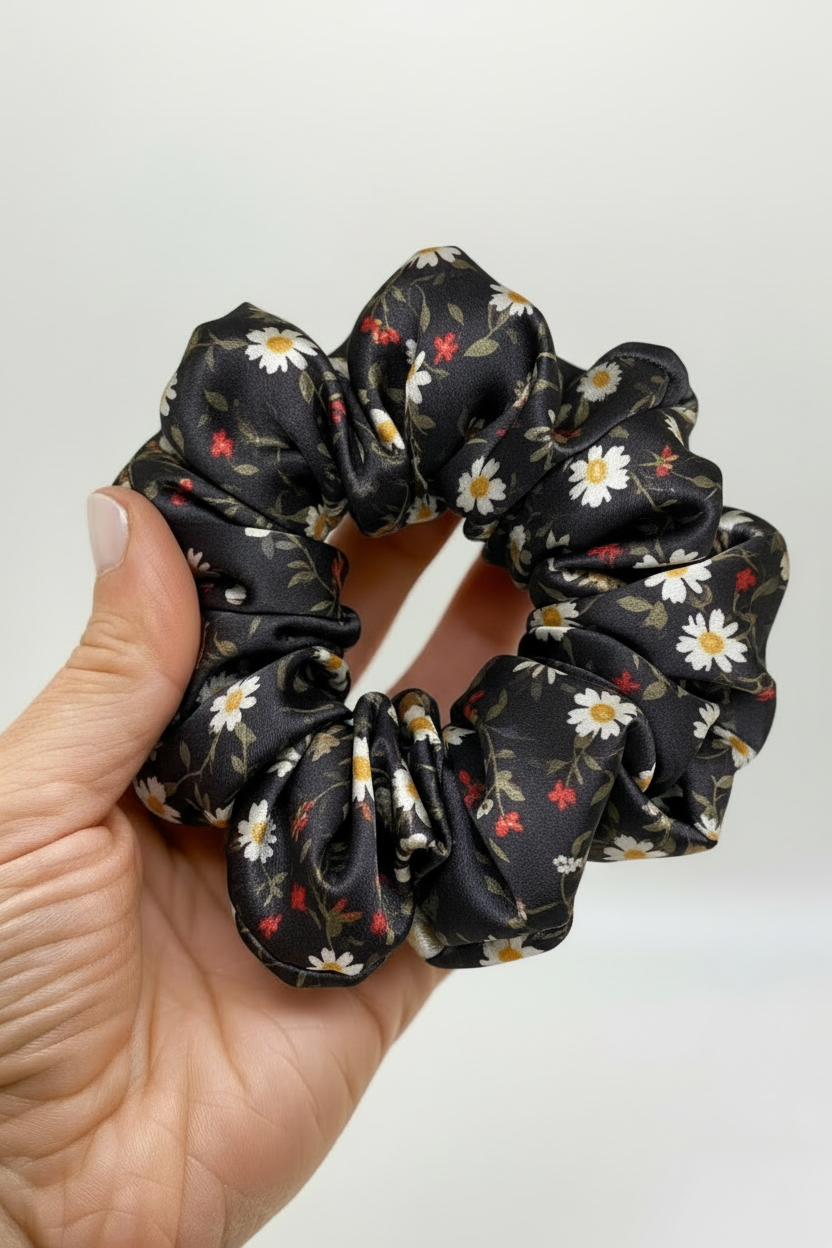 Hand holding black floral scrunchie